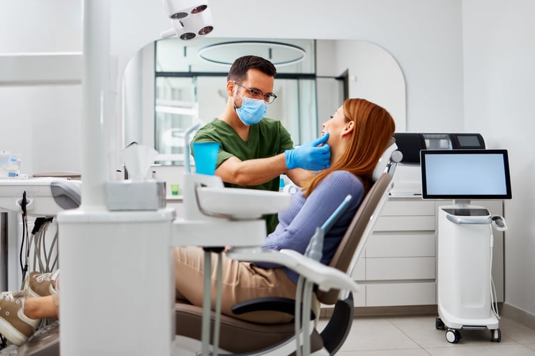 Dentist examining a patient's mouth for oral health during a routine dental visit